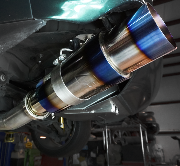 Powerhouse Racing timing gear, billet pulleys, manifold components, and fabrication accessories displayed—performance upgrades for Toyota Supra 2JZ builds.